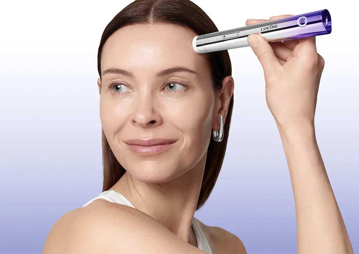 Ženska uporablja Lancôme Rénergie Nano-Resurfacer napravo na čelu med nego kože.