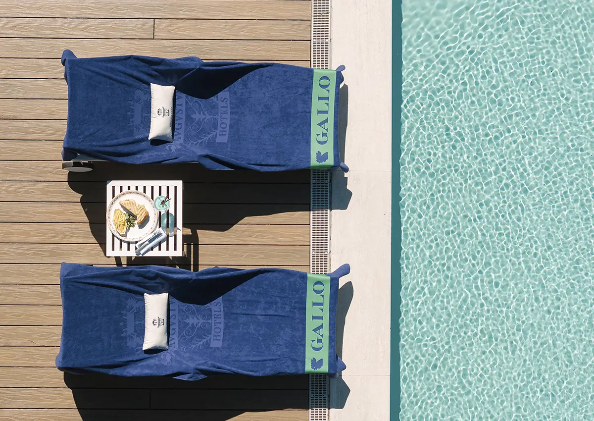 Ležalnika ob bazenu z modrimi brisačami Gallo v letovišču Augustus v Forte dei Marmi.