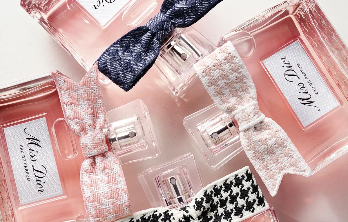 Steklenička Miss Dior Eau de Parfum s srebrno pentljo in rožnato obarvano dišavo