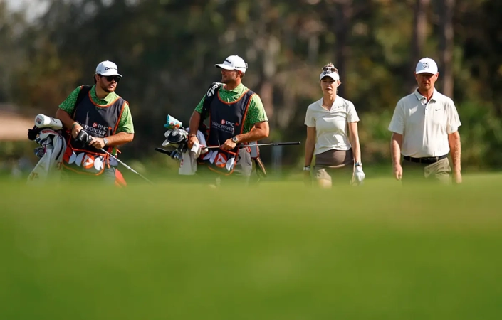 pnc-championship-2026 Nelly Korda z očetom Petrom in njunima spremljevalcema na golfskem igrišču med PNC Championshipom.