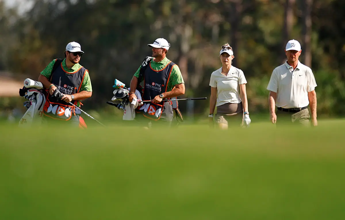 Nelly Korda z očetom Petrom in njunima spremljevalcema na golfskem igrišču med PNC Championshipom.